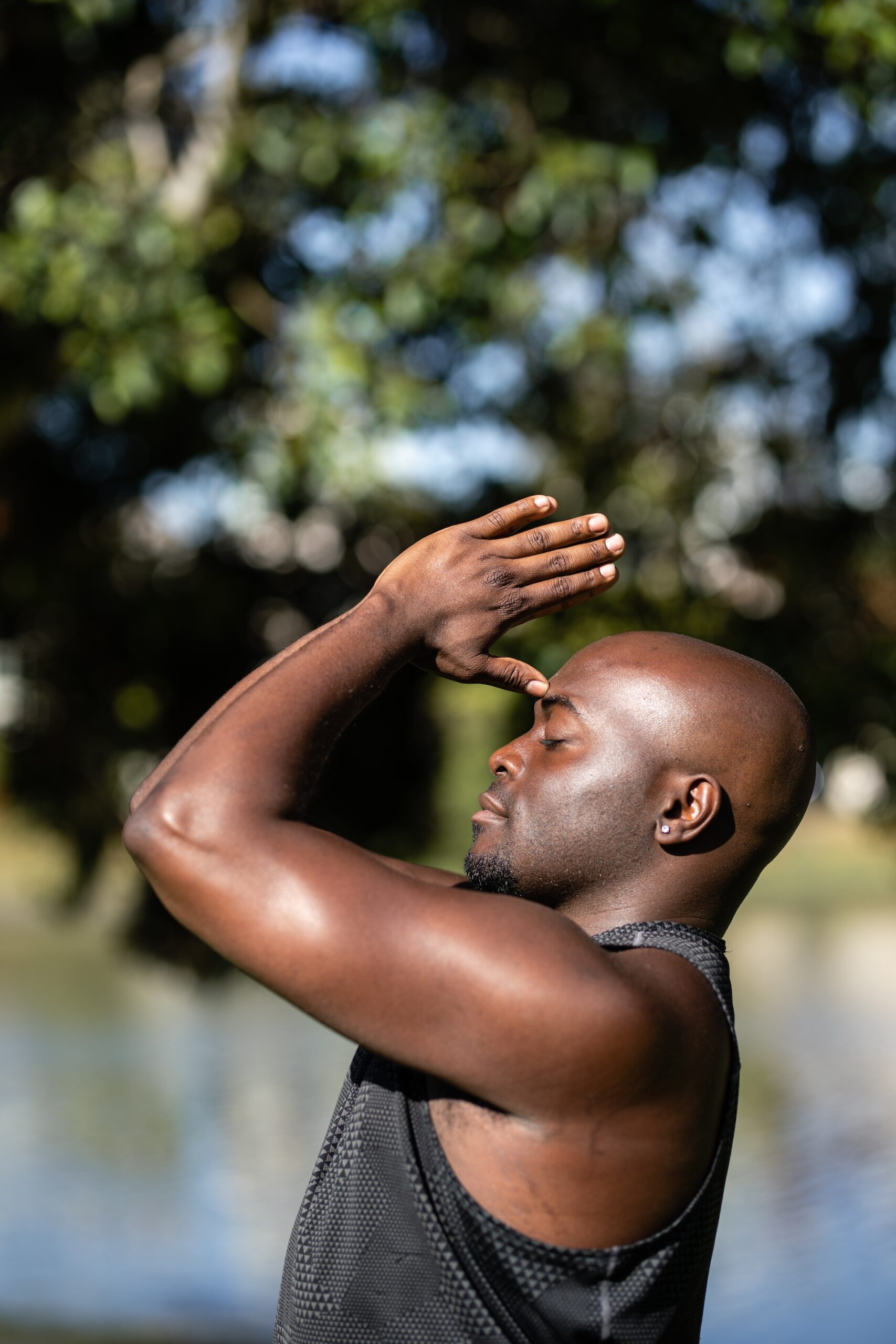 Man doing yoga with hands to head.